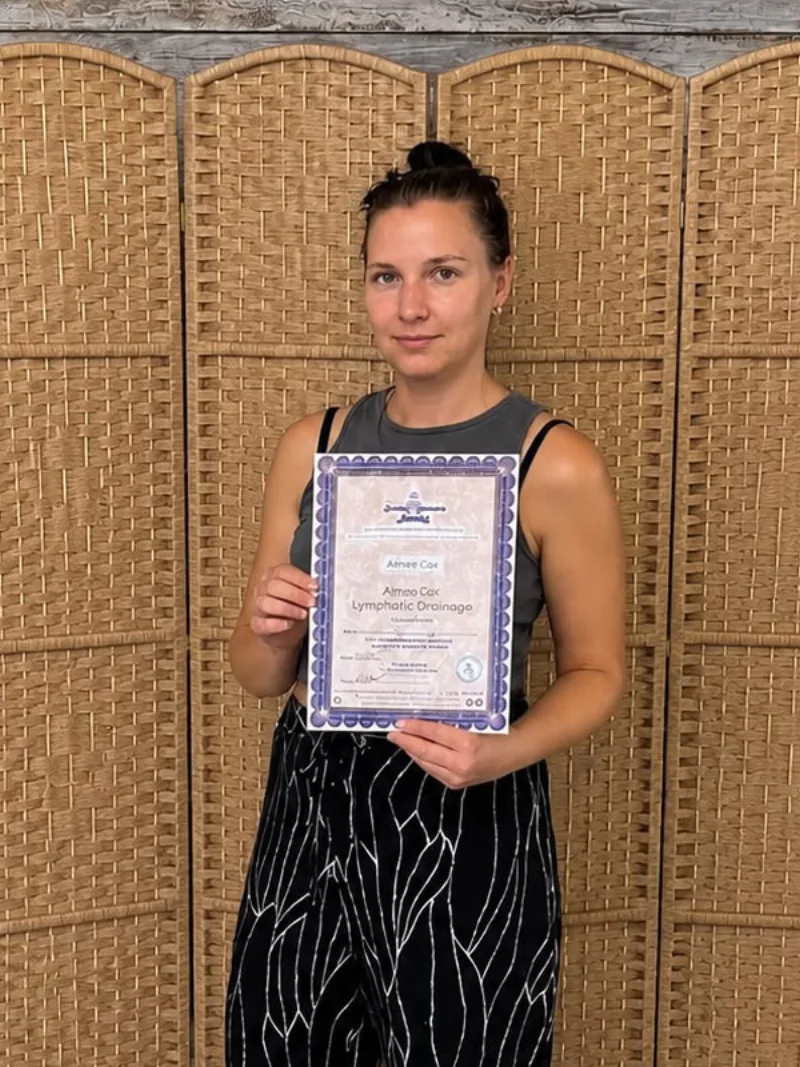 Aime, the therapist behind Willow & Flow Holistic Therapies, holding her Lymphatic Drainage qualification certificate